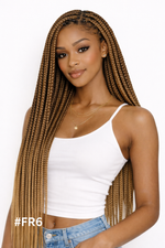 Woman with long braided hair wearing a white top and blue jeans on a white background in Qatar